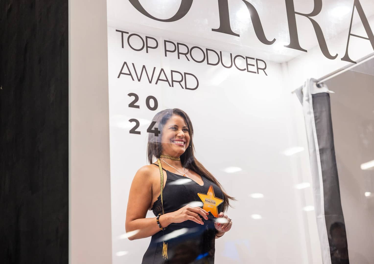 Woman holding a star shaped trophy while posing inside the magazine photo booth rental