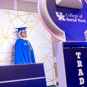 A graduate taking a photo on the custom trading card photo booth