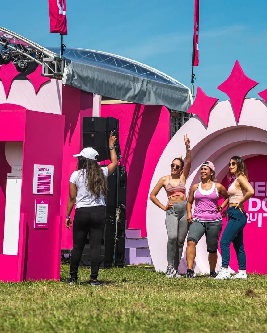 Custom Orlando Photo Booth 5D set build. Women taking photos from the photo booth, while standing in front a pink 5D backdrop