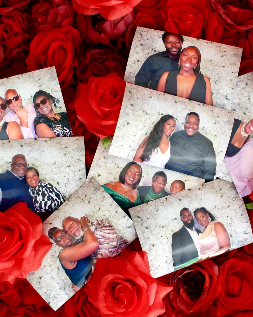 Prints from a photo booth rental laying on a red flower wall